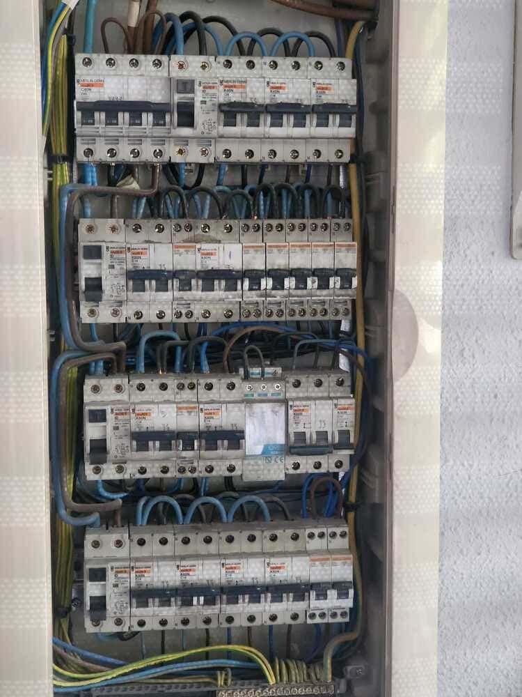 Panel de interruptores eléctricos con numerosos interruptores y cableado.