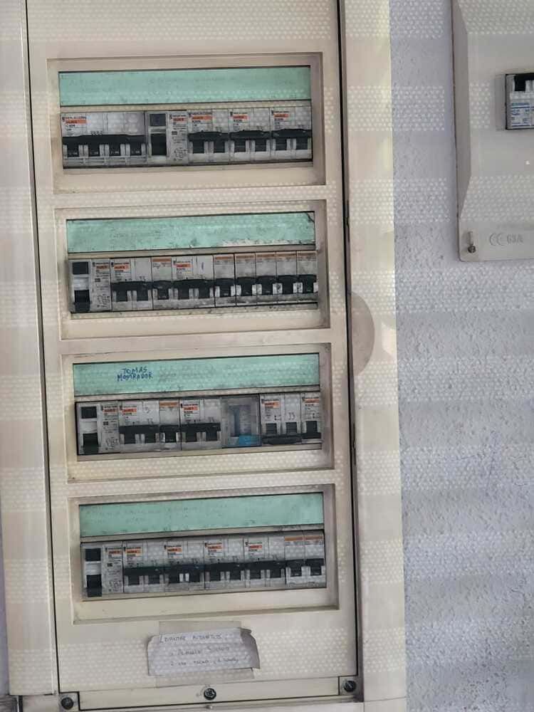 Panel de disyuntores eléctricos con múltiples filas de interruptores.