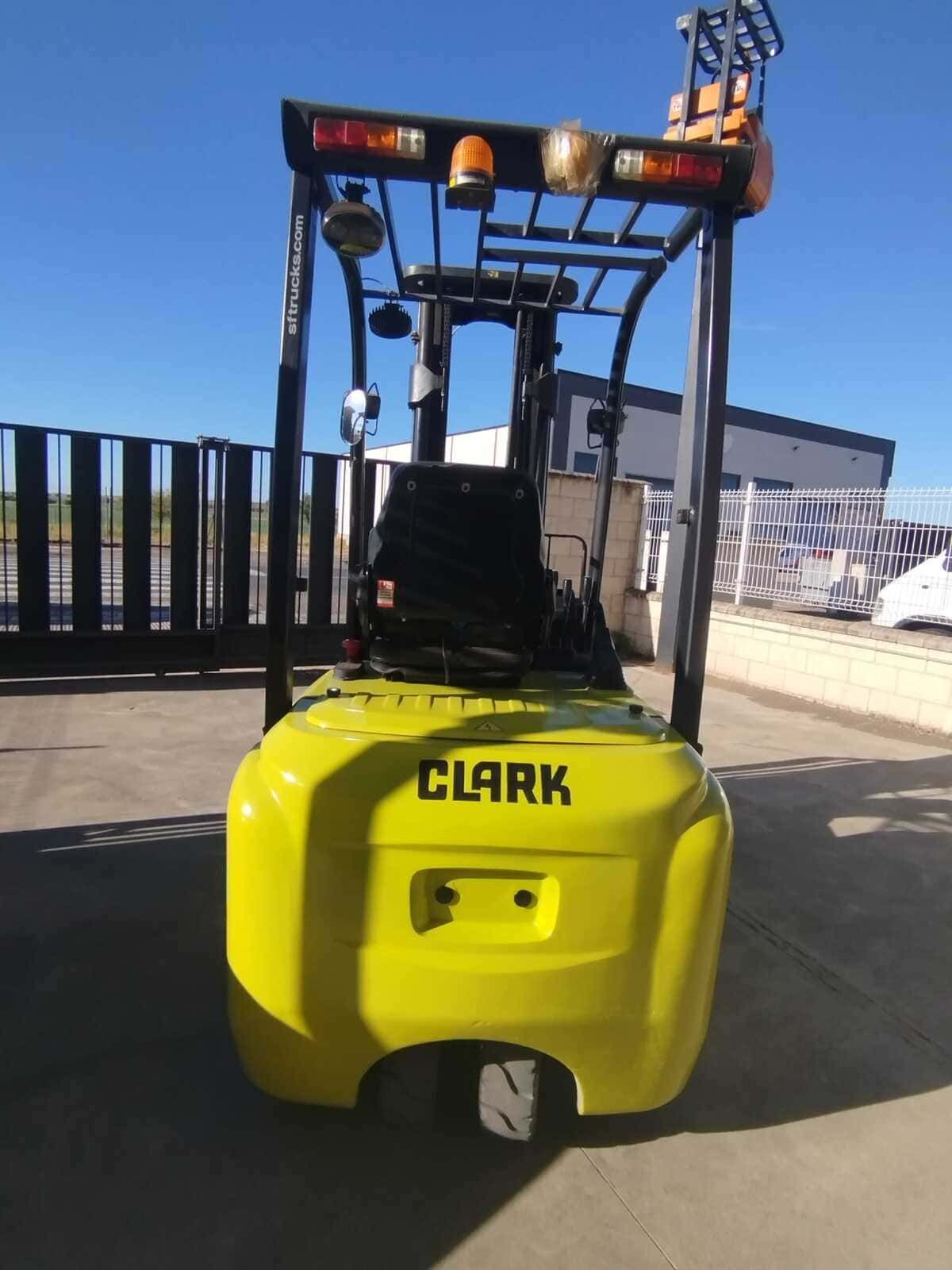 Vista trasera de una carretilla elevadora Clark de color amarillo brillante estacionada al aire libre en un día soleado.