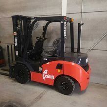 Una carretilla elevadora roja está estacionada en un almacén.