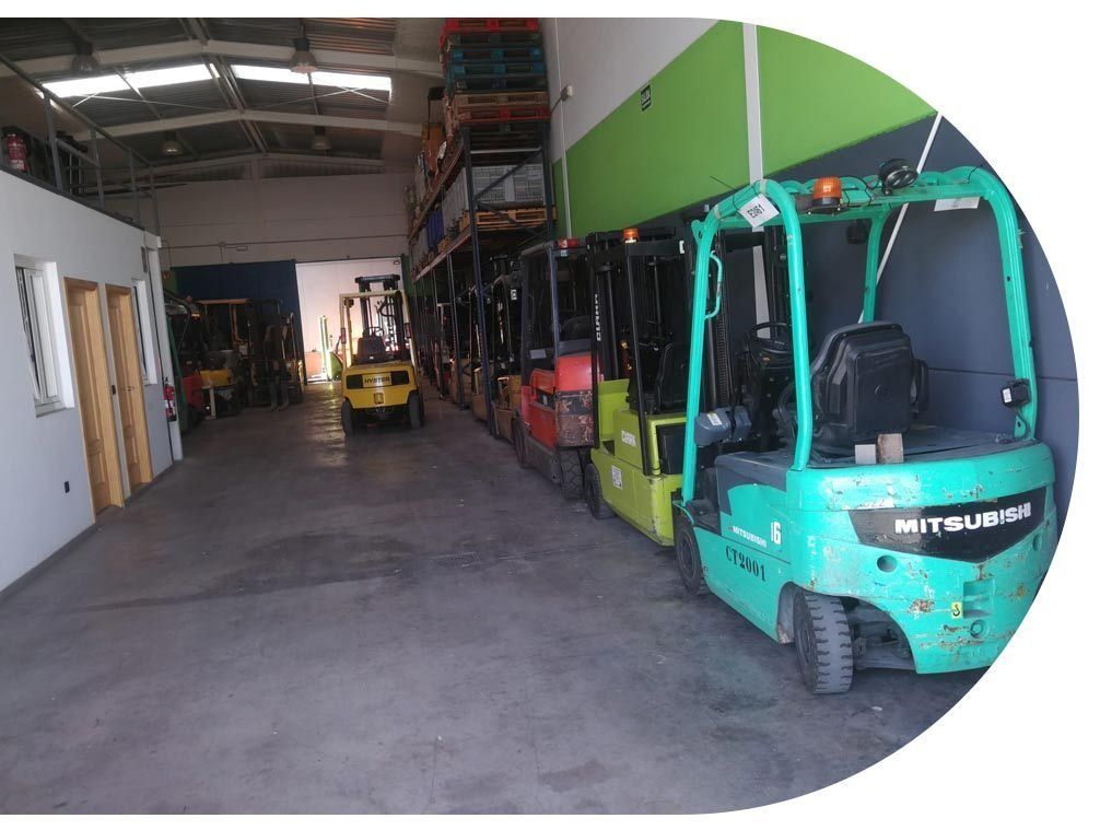 Una fila de carretillas elevadoras están estacionadas en un almacén