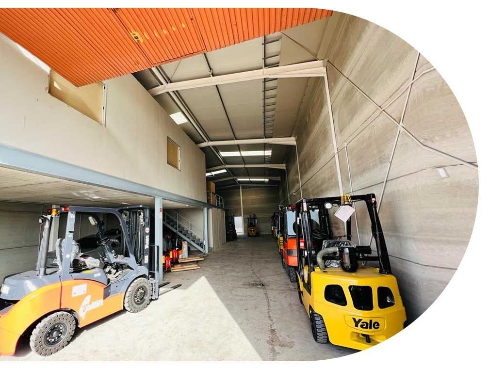 Una carretilla elevadora Yale está estacionada en un gran almacén.