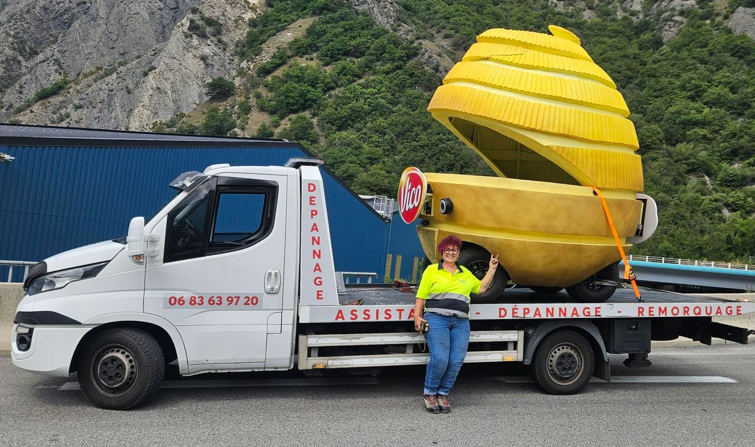 Une dépanneuse avec un véhicule en forme de pomme de terre dessus