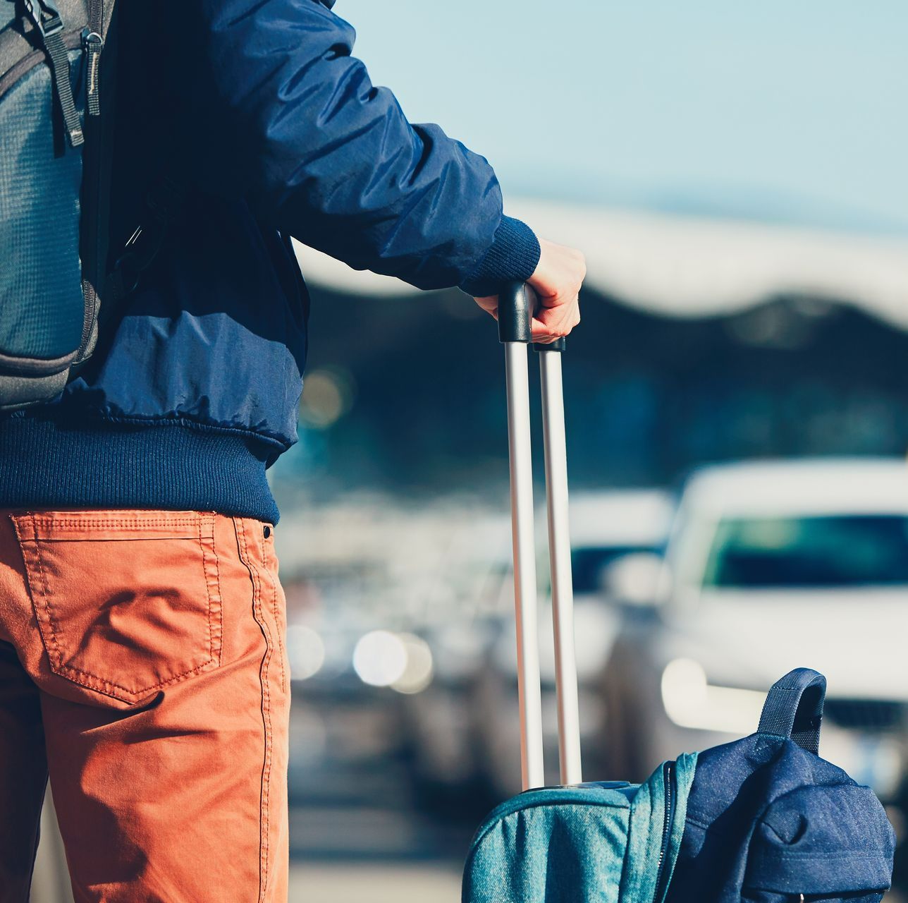 Un homme portant un sac à dos et tenant une valise