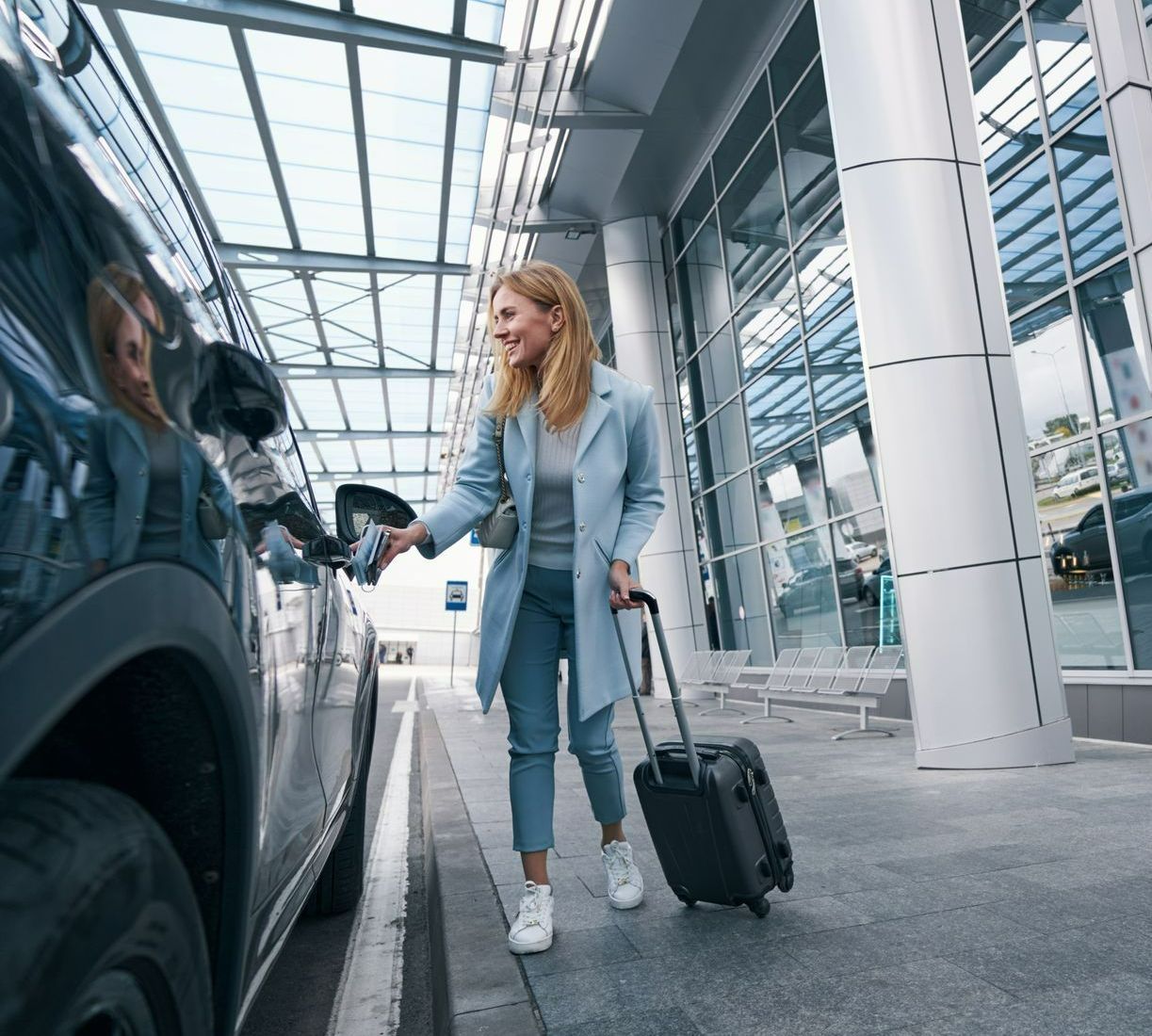 Une femme avec une valise montant dans un taxi