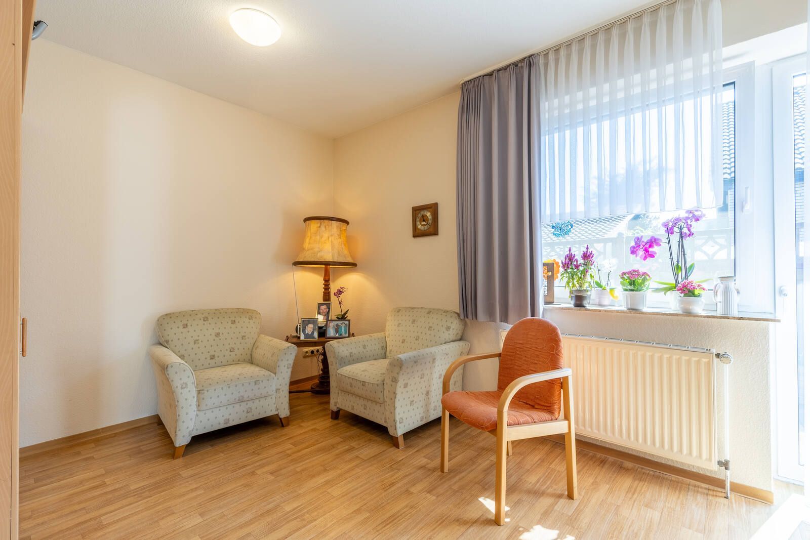 Ein Wohnzimmer mit zwei Stühlen und einer Lampe.