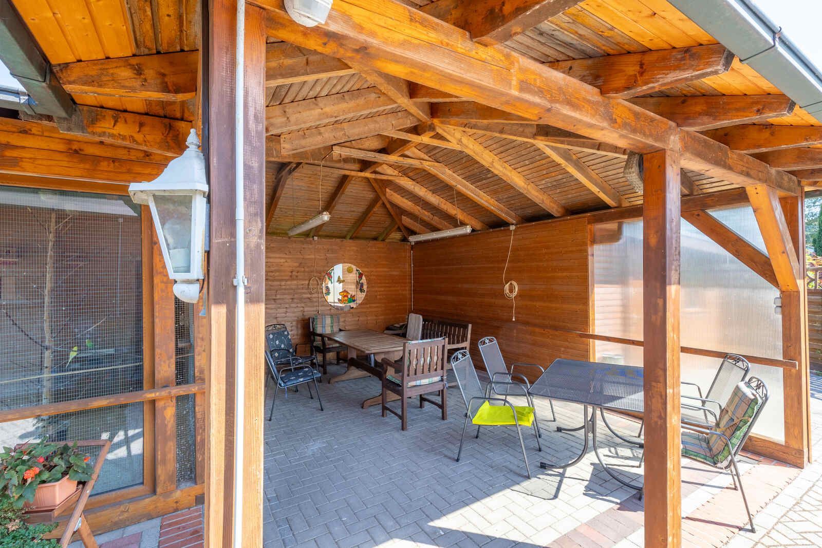 Ein hölzerner Pavillon mit einem Tisch und Stühlen darunter.