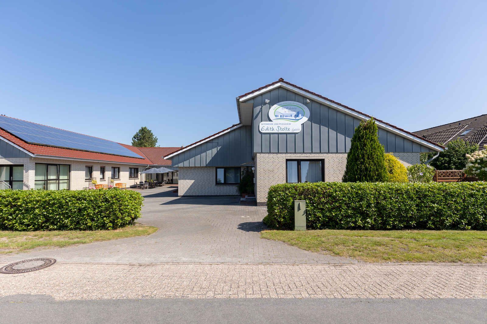 Ein großes Altenwohn- und Pflegeheim mit vielen Fenstern und einer Auffahrt davor.