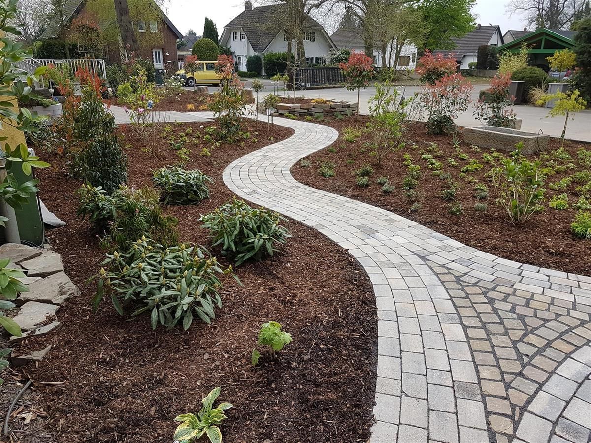 Ein Ziegelweg schlängelt sich durch einen üppigen grünen Garten