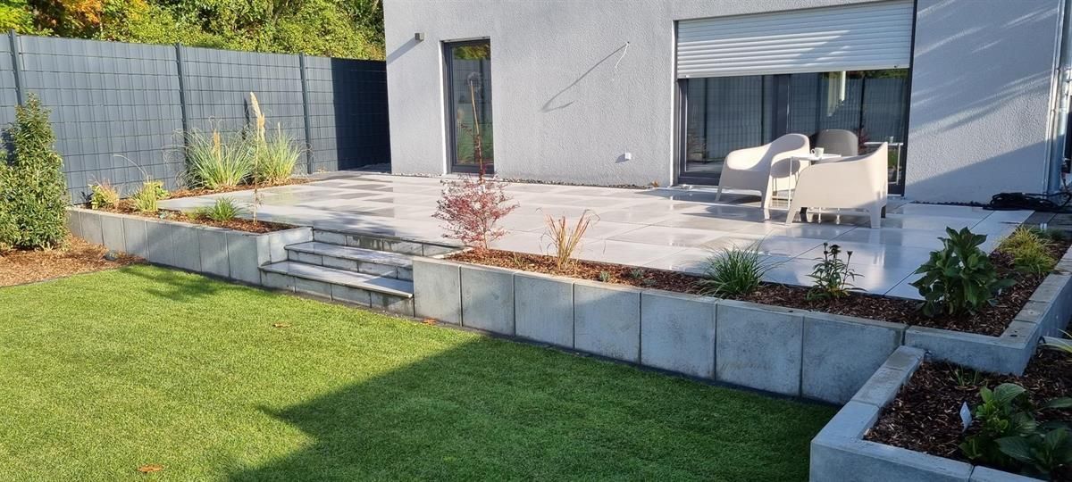 Im Hinterhof eines Hauses gibt es einen Terrassenbereich.