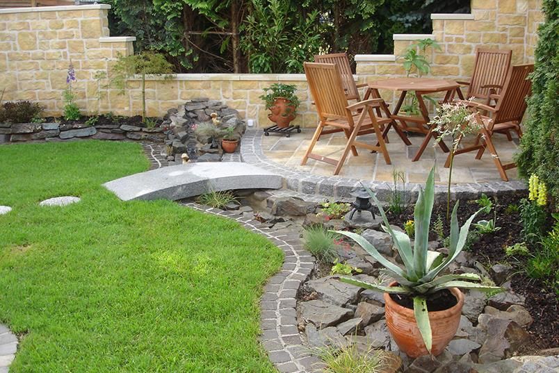 Ein Garten mit Tisch und Stühlen und einer Topfpflanze