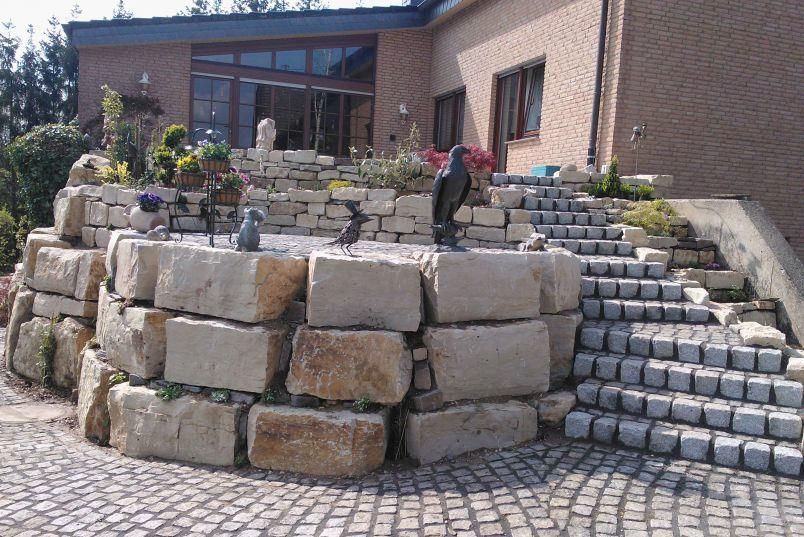 Eine Steinmauer mit Treppen, die zu einem Haus führen