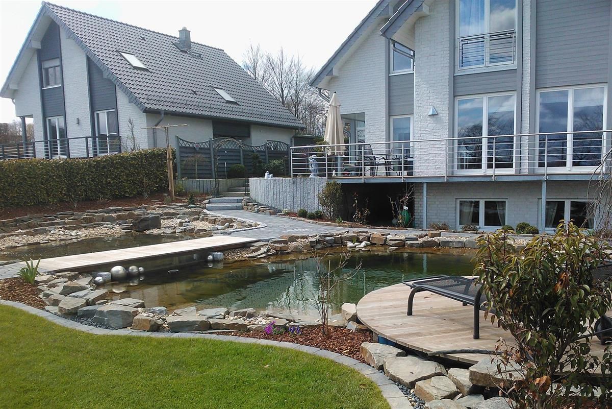 Ein großes Haus mit einem Teich davor