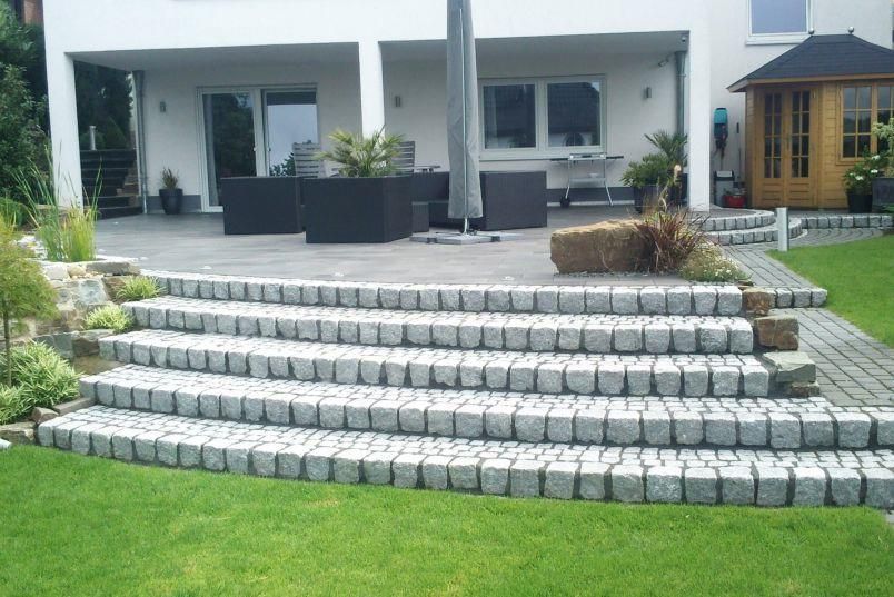 Eine Treppe, die zu einer Terrasse vor einem Haus führt