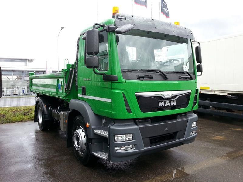 Ein grüner Muldenkipper steht auf einem Parkplatz