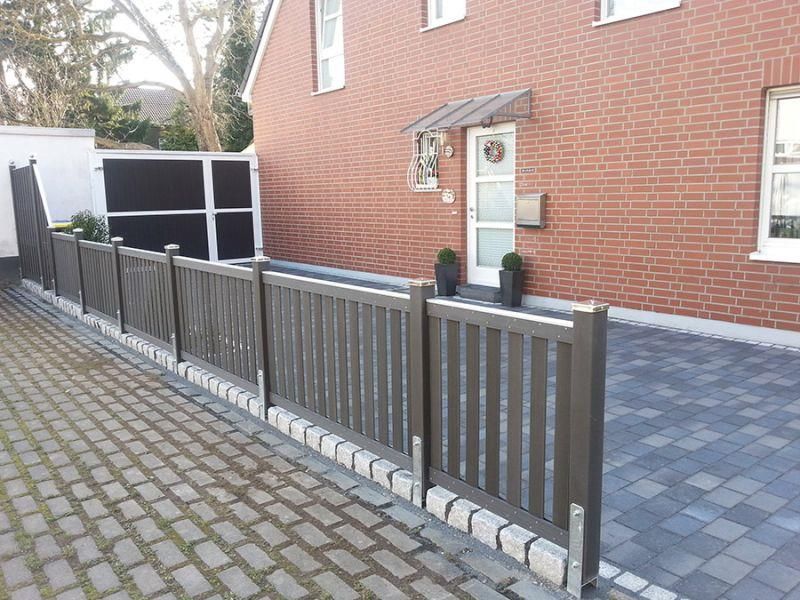 Ein Backsteinhaus mit einem Zaun davor