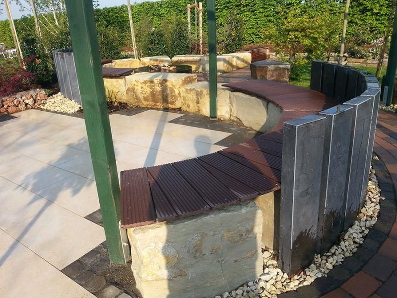 Eine Holzbank steht mitten in einem Garten