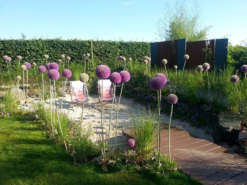 Ein Garten voller lila Blumen und Stühle