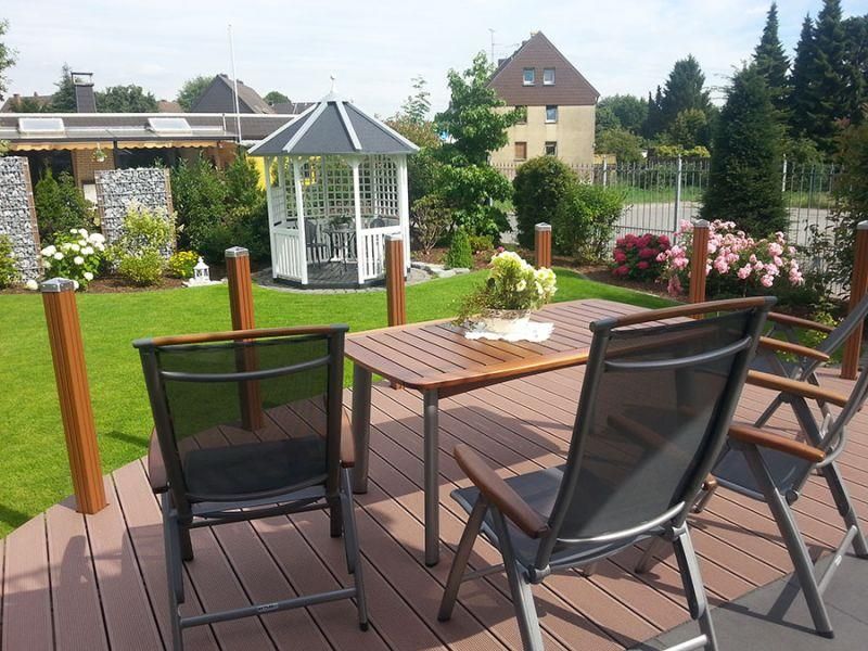 Ein Tisch und Stühle auf einer Terrasse mit einem Pavillon im Hintergrund