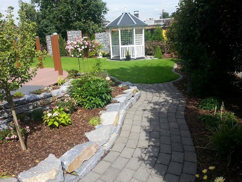 Ein Ziegelweg führt zu einem Pavillon in einem Garten