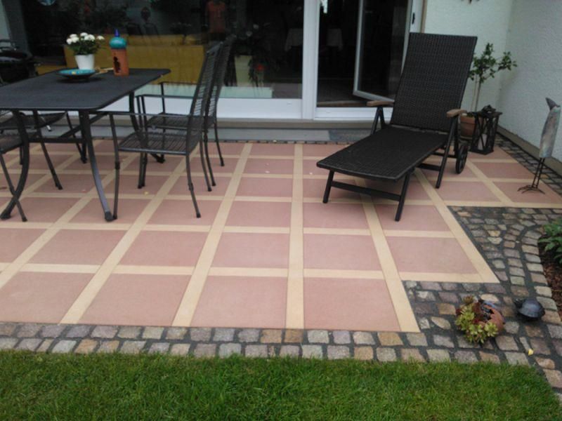 Eine Terrasse mit Tisch, Stühlen und Liegestuhl