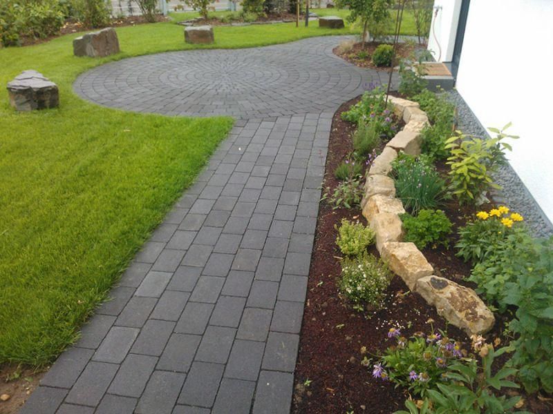 Ein Ziegelweg in einem üppigen grünen Garten