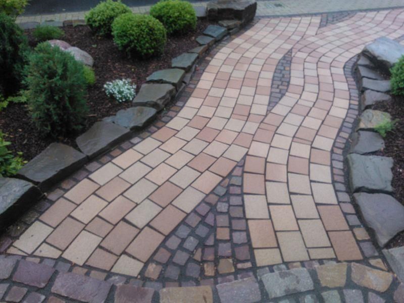 Ein geschwungener Gehweg aus Ziegeln und Steinen