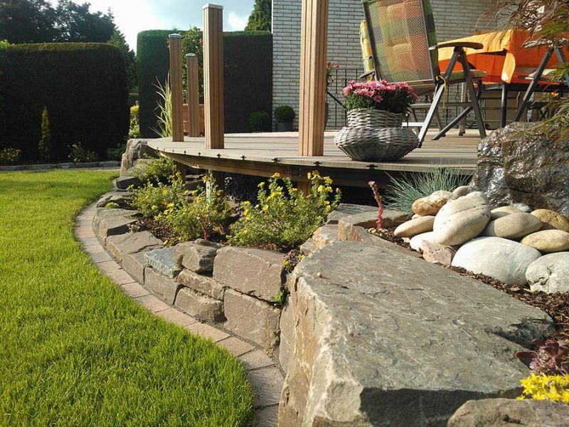 Ein Deck mit einem Stuhl und einer Vase mit Blumen darauf