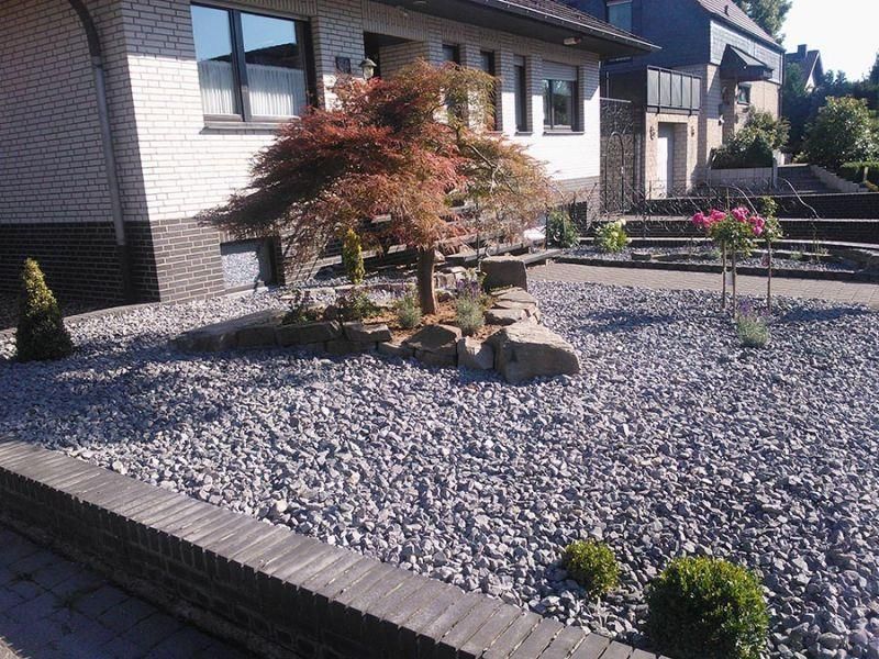 Ein Haus mit einem Kiesplatz davor