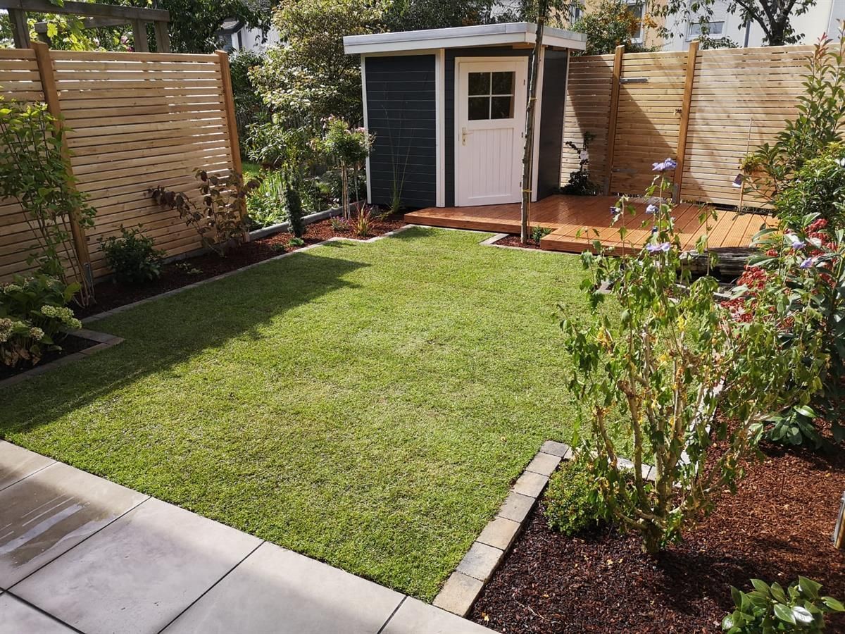 Ein kleiner Schuppen steht inmitten eines üppigen grünen Gartens