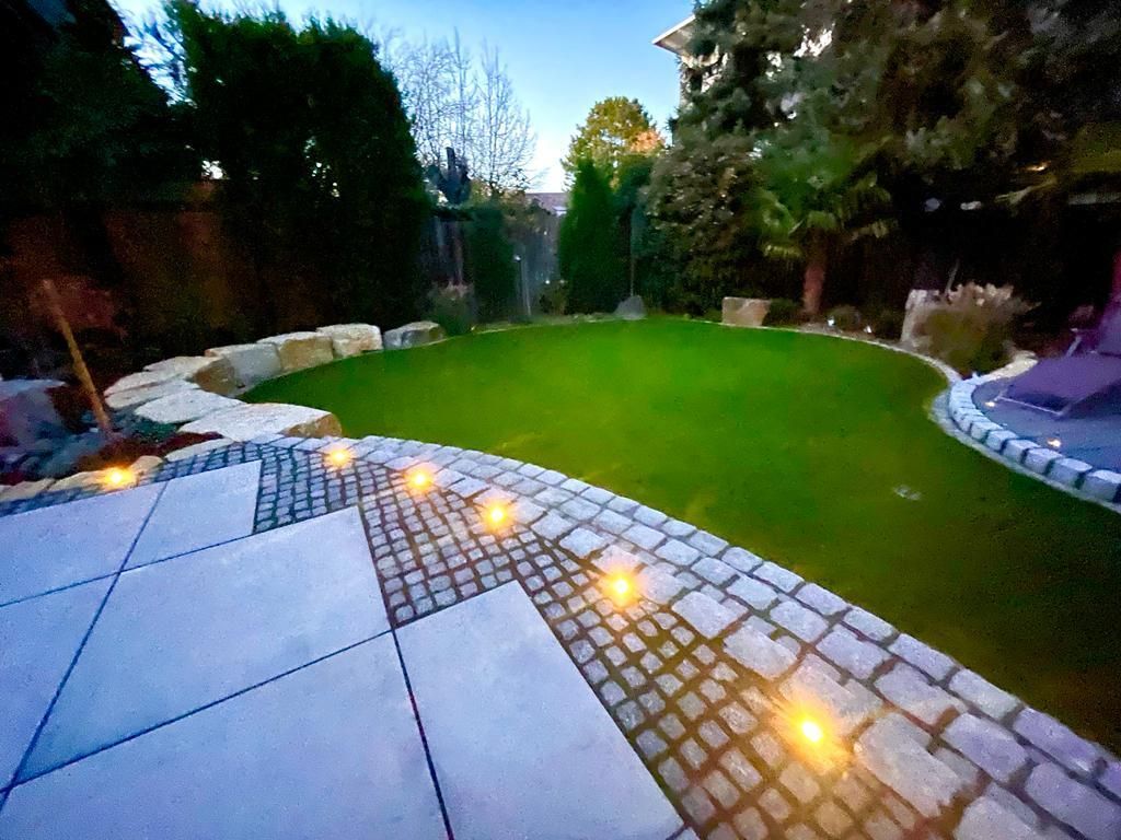 Ein Hinterhof mit einem Ziegelweg und einem üppigen grünen Rasen