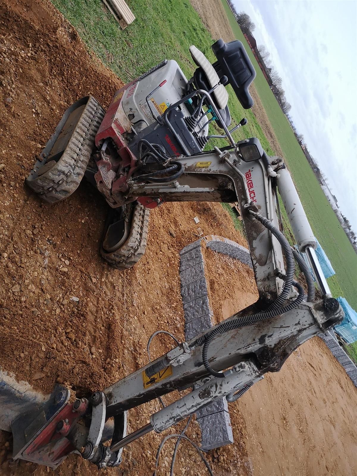 Ein Bagger steht auf einem Erdhaufen.