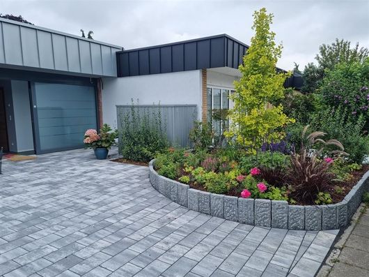 Ein Haus mit einer Auffahrt und einem Garten davor