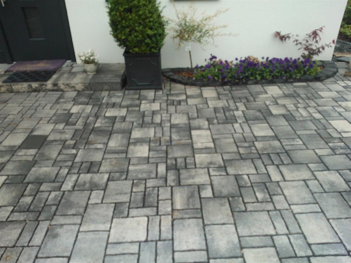 Eine gemauerte Auffahrt vor einem weißen Haus