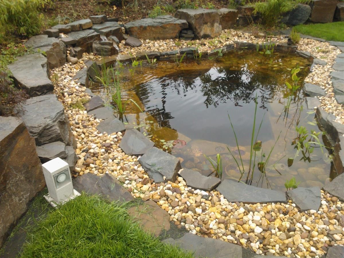 Ein kleiner Teich, umgeben von Felsen und Kies