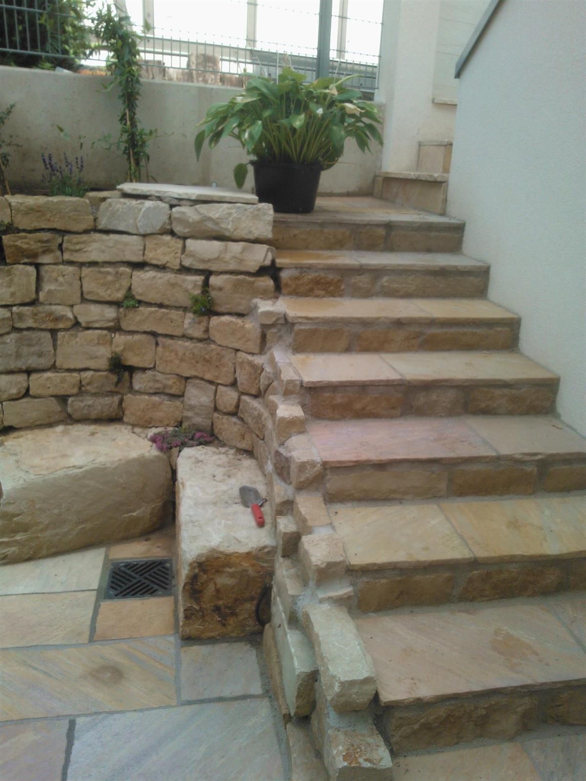 Eine Steintreppe mit einer Topfpflanze an der Seite