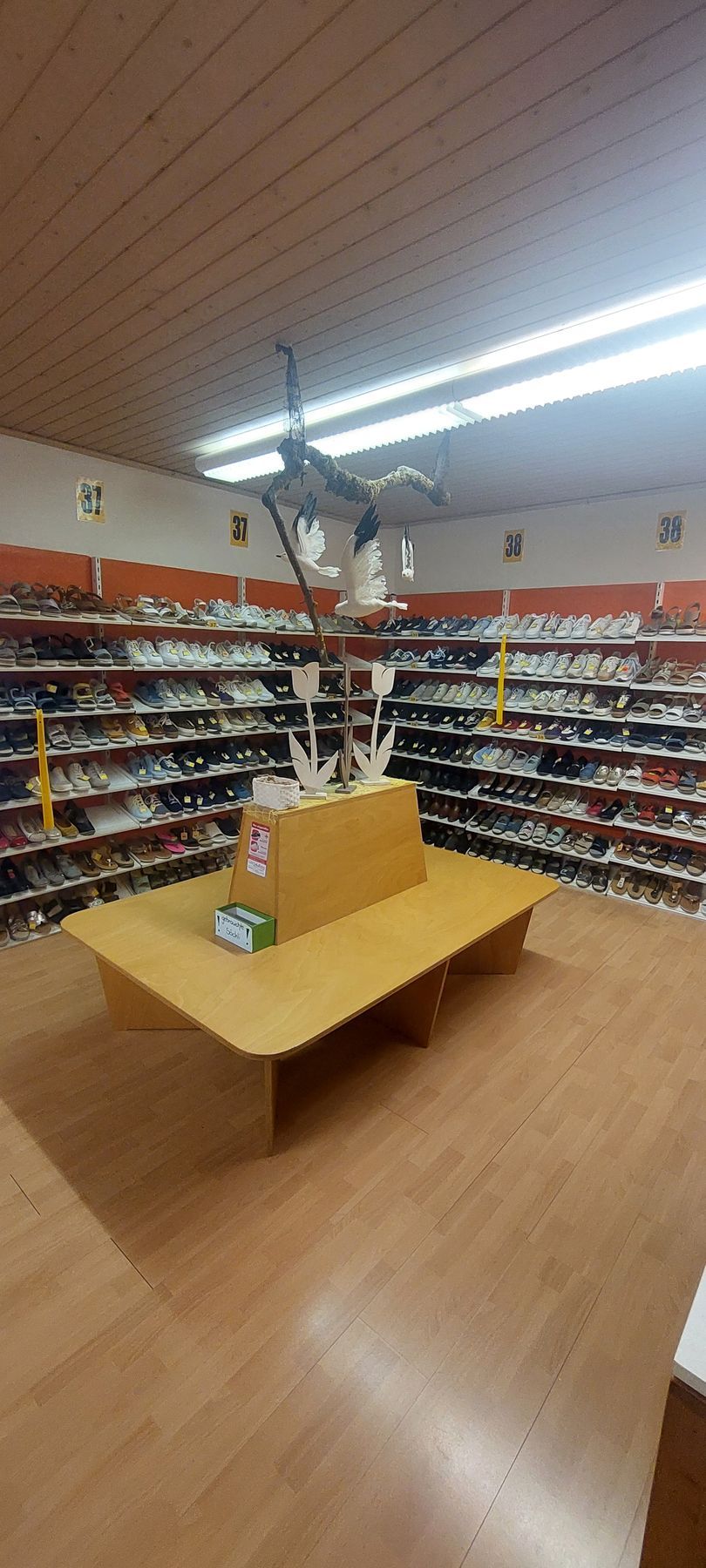 Gang in einem Lebensmittelladen mit Regalen voller Snacks und Getränken, gesehen von der Nähe der Kasse aus.