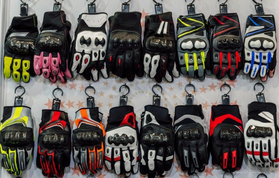 Reihenweise hängen bunte Motorradhandschuhe zum Verkauf.