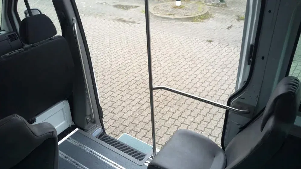 Eintritthilfe mit ausfahrbaren Stufen und Handlauf im Rückraum des Personenbeförderungswagens