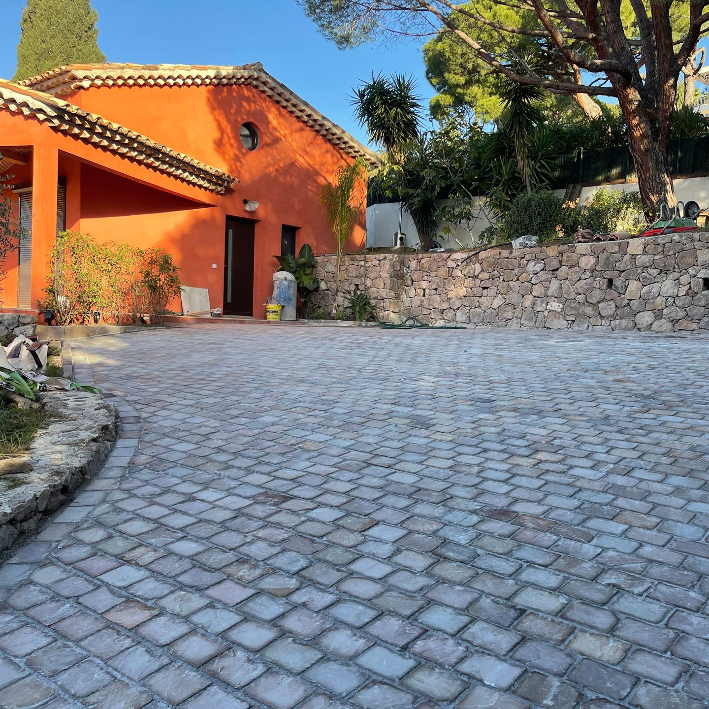 Allée pavée devant un maison orange.