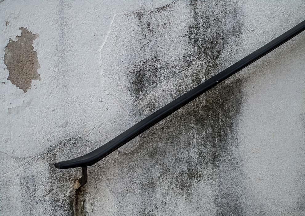 Ein schwarzes Geländer ist an einer weißen Wand befestigt