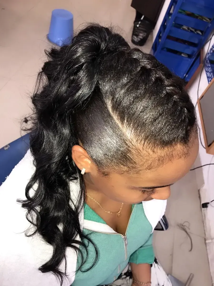 Una estilista aplica mechas con papel de aluminio en el cabello largo y castaño de una clienta en un salón de belleza.