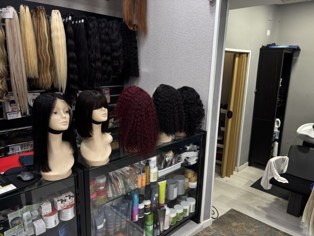 Fila de cabezas de maniquí rubias con cabello largo en el escaparate de una tienda.