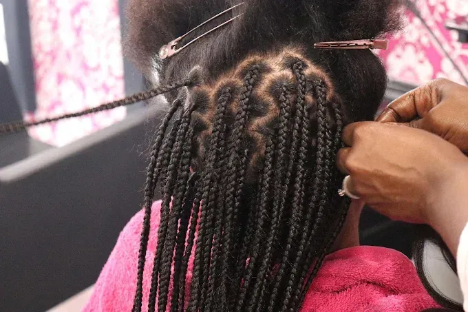 Retrato de perfil de una mujer con adornos florales en el cabello, con los ojos cerrados.