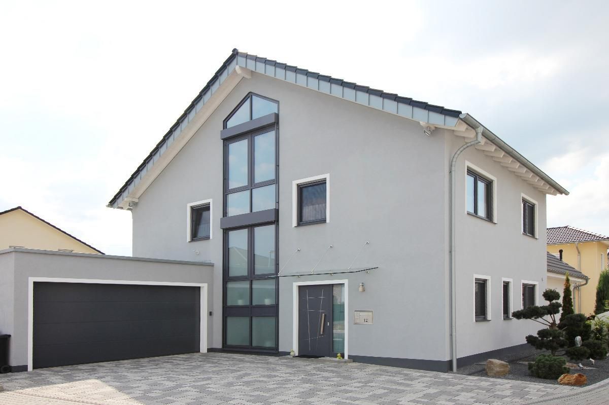 Ein großes weißes Haus mit einem schwarzen Garagentor