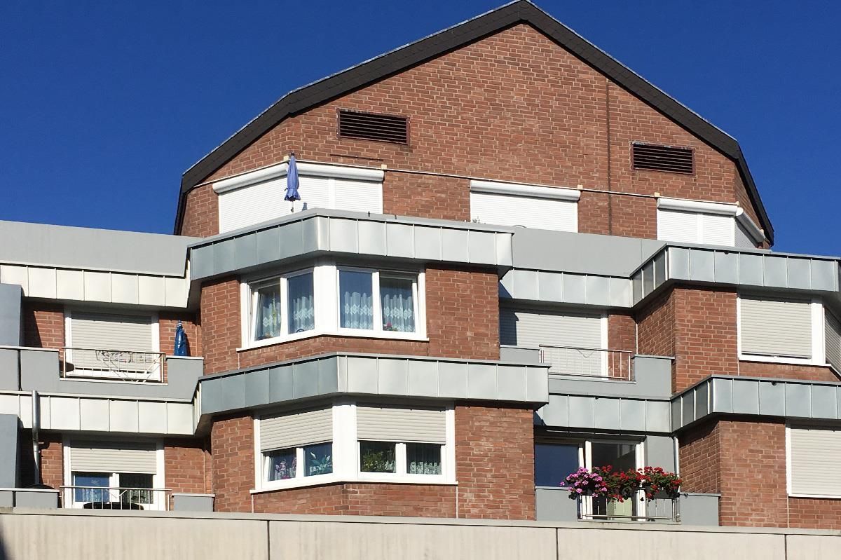 Ein Backsteingebäude mit Balkonen und Fensterläden