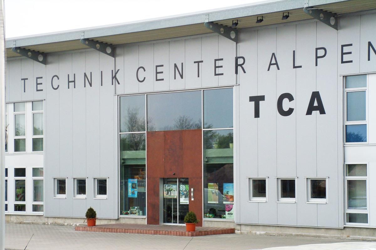 Die Vorderseite eines Gebäudes mit der Aufschrift „Technik Center Alpen TCA“
