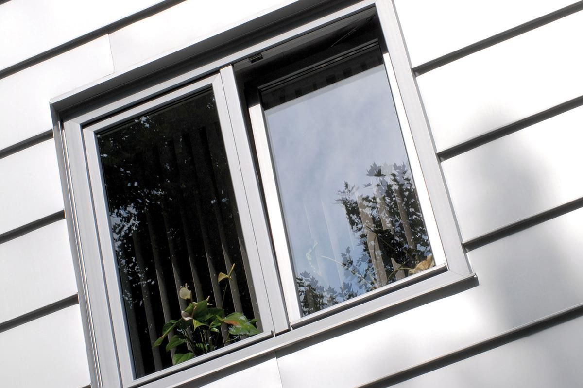 Ein Fenster mit einer Spiegelung von Bäumen darin