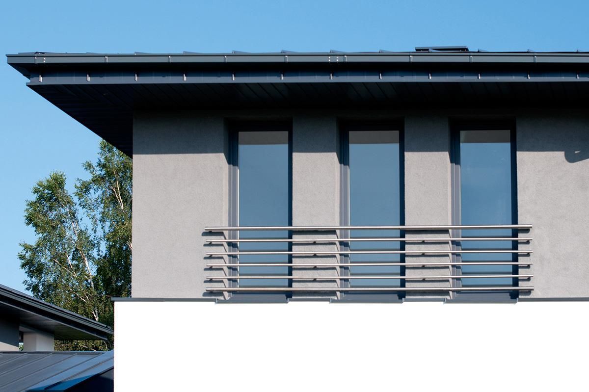 Ein Haus mit Balkon und blauem Himmel im Hintergrund