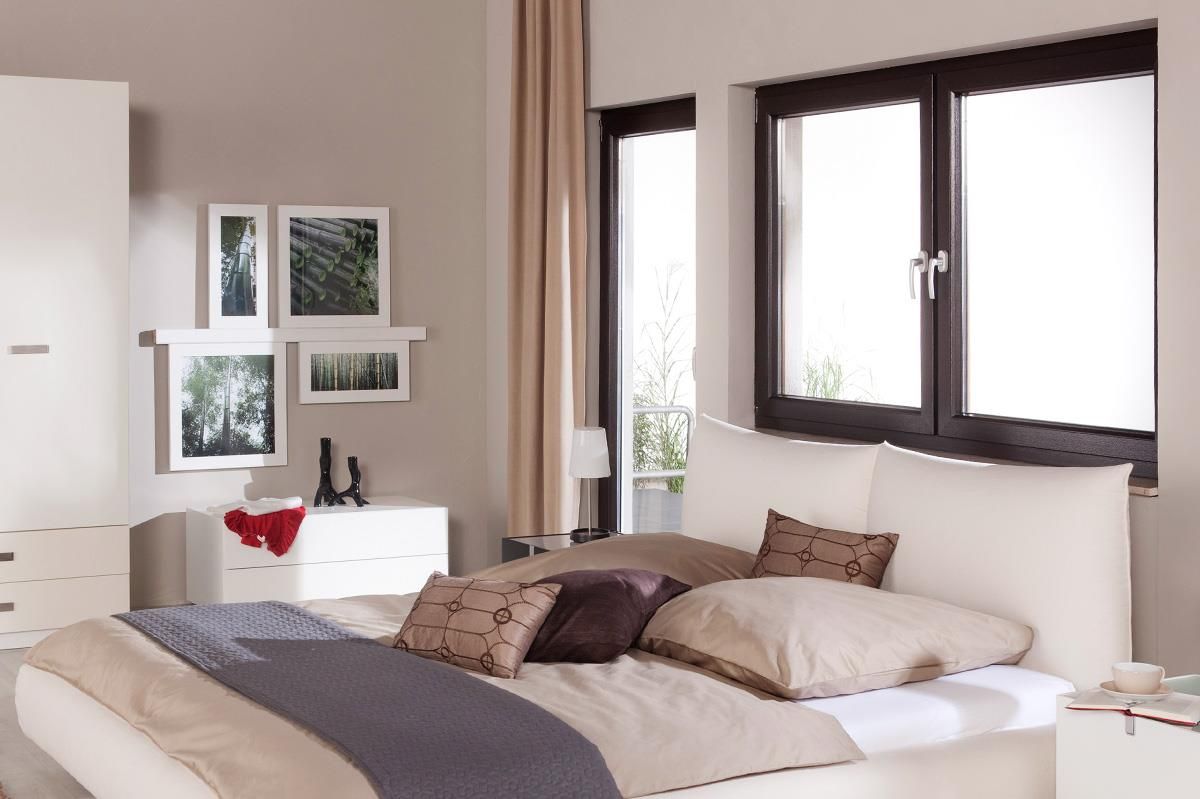 Ein Schlafzimmer mit großem Bett und zwei Fenstern